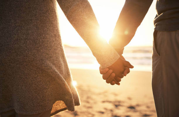 Paar geht Hand in Hand - Sonnenuntergang - glücklich - Bedürfnisse - Lilien Institut Paartherapie Wiesbaden